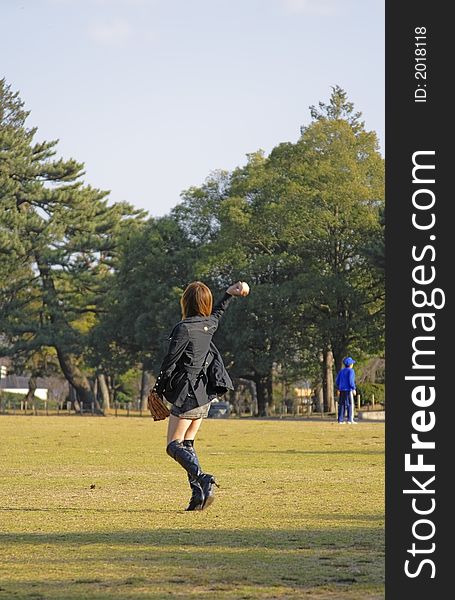 Sexy girl with high-heels playing baseball in a park.Useful as educational image in designs connected with mass sport idea. Sexy girl with high-heels playing baseball in a park.Useful as educational image in designs connected with mass sport idea.