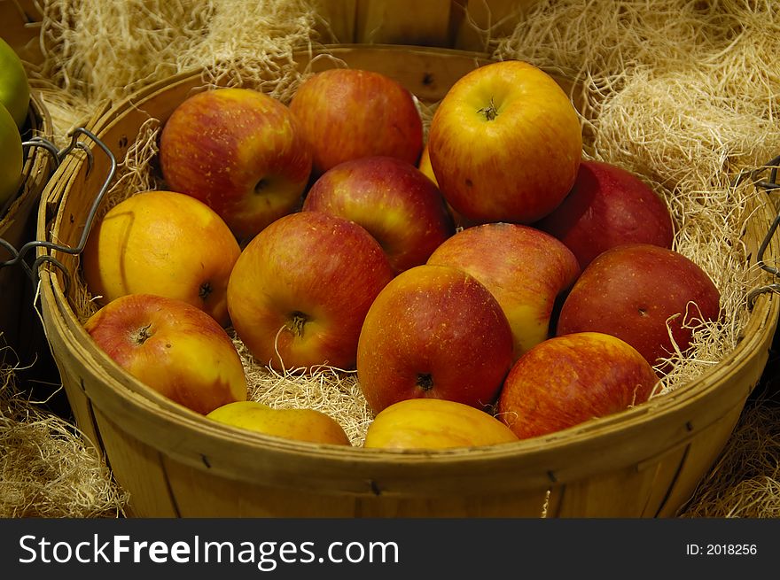 A bunch of apples in a wooden basket. A bunch of apples in a wooden basket