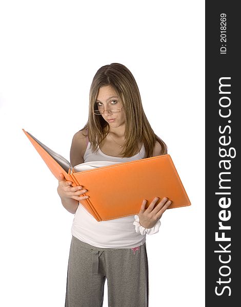 Teenager looking up from orange book with glasses on, no smile. Teenager looking up from orange book with glasses on, no smile