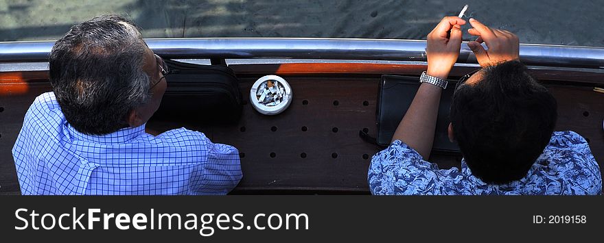 Two friends sitting together and smoking, enjoying the view. Two friends sitting together and smoking, enjoying the view