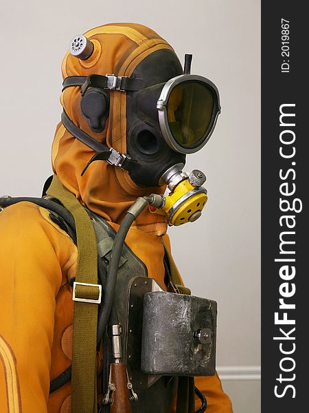 The mannequin is dressed in a orange diving suit with a cargo, hoses and a rubber mask
