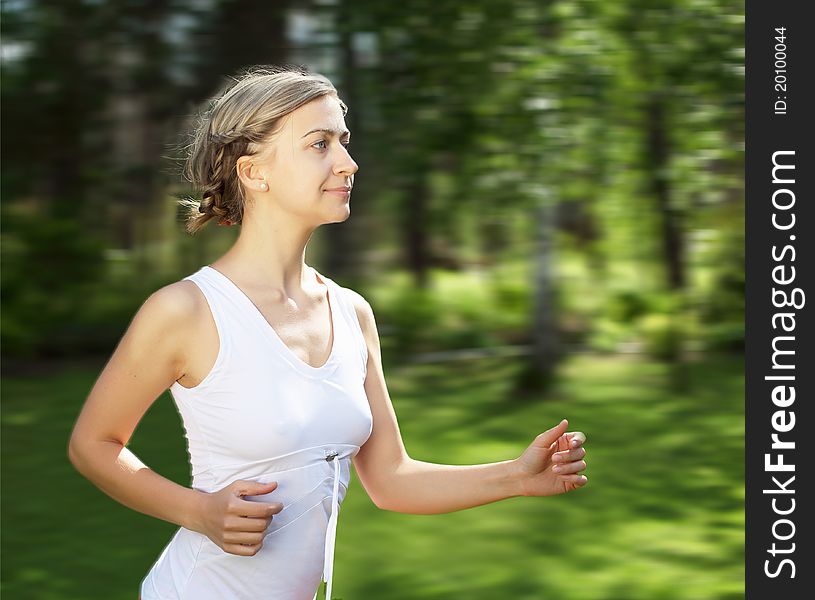 Young girl in a white shirt and red pants likes to run outdoors.