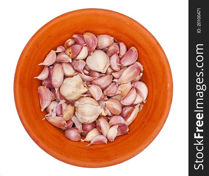 Garlic on a red plate on a white background, isolated. Garlic on a red plate on a white background, isolated