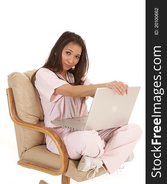 A woman in her scrubs sitting in a chair looking at the computer with a upset expression on her face. A woman in her scrubs sitting in a chair looking at the computer with a upset expression on her face.