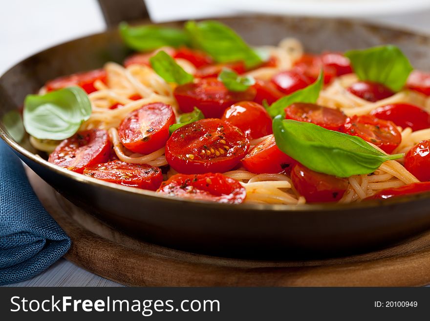 Spaghetti with cherry tomato on a rustic pan