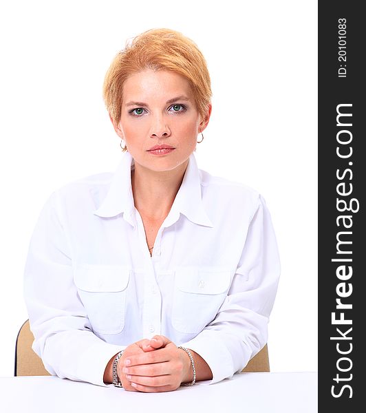 Blond smiling businesswoman sitting at her desk isolated on white background. Blond smiling businesswoman sitting at her desk isolated on white background