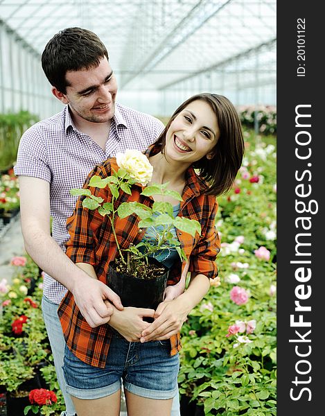 An image of a young couple with a flower pot. An image of a young couple with a flower pot