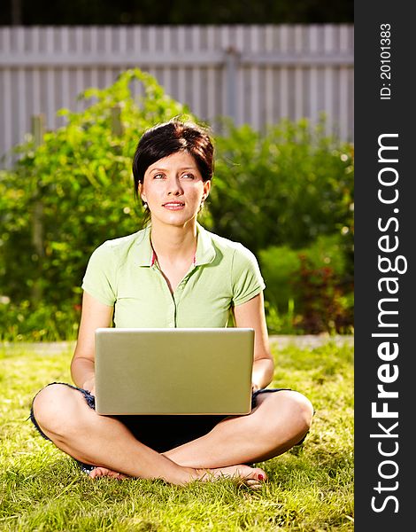 Caucasian woman is lying on the grass with laptop. Caucasian woman is lying on the grass with laptop