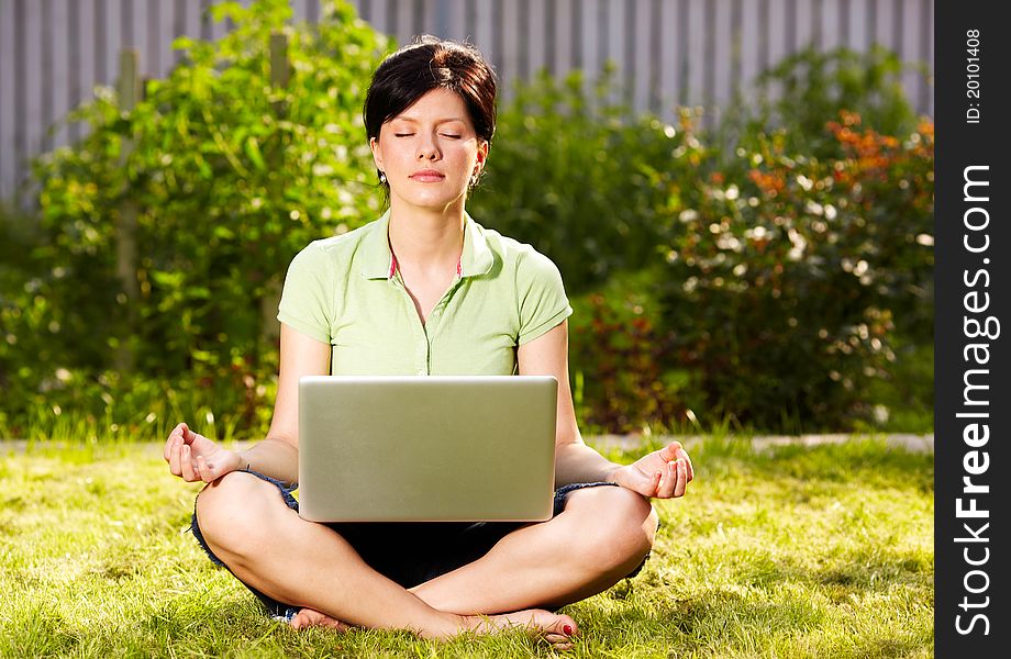 Caucasian woman is relaxing on the grass with laptop. Caucasian woman is relaxing on the grass with laptop