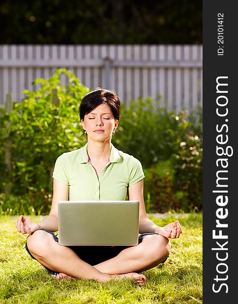 Caucasian woman is relaxing on the grass with laptop. Caucasian woman is relaxing on the grass with laptop