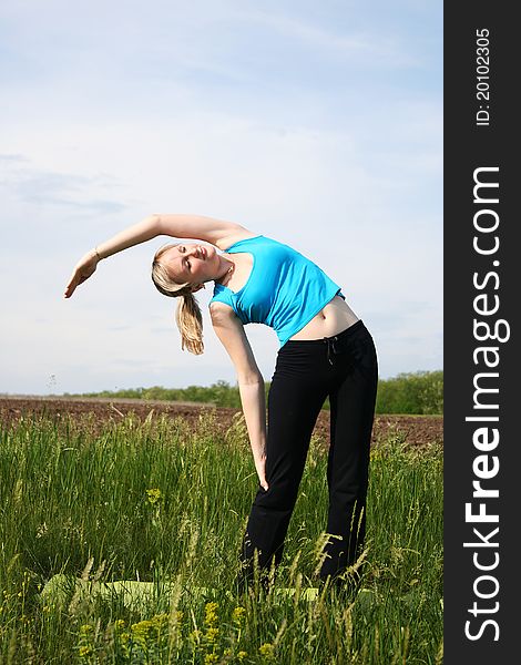 Young woman doing exercises outdoors. Young woman doing exercises outdoors