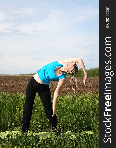 Young woman doing yoga exercises outdoors. Young woman doing yoga exercises outdoors