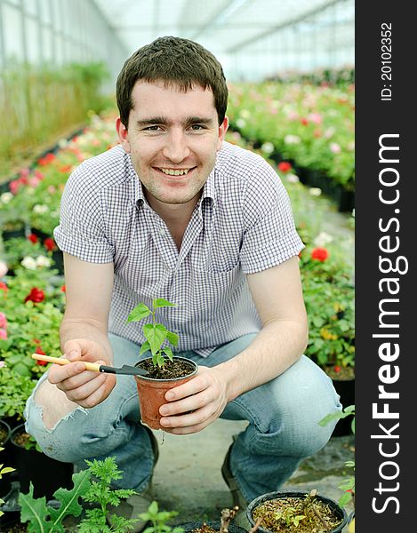 An image of a man with a plant in a pot. An image of a man with a plant in a pot