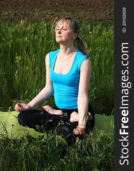 Young woman doing yoga exercises outdoors. Young woman doing yoga exercises outdoors