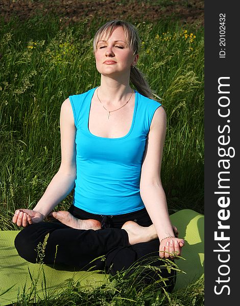 Young woman doing yoga exercises outdoors. Young woman doing yoga exercises outdoors