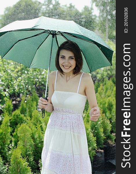 An image of a young girl with a green umbrella. An image of a young girl with a green umbrella