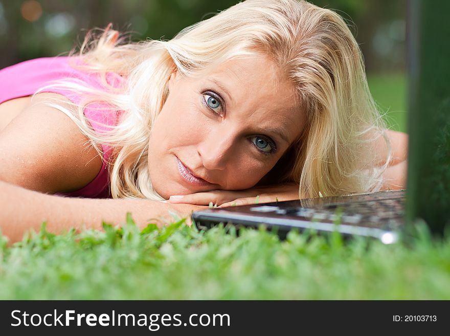 Young attractive woman relax at the park with her laptop