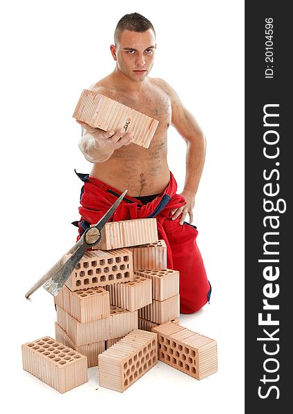 Handsome young worker with a pickaxe and bricks. Handsome young worker with a pickaxe and bricks