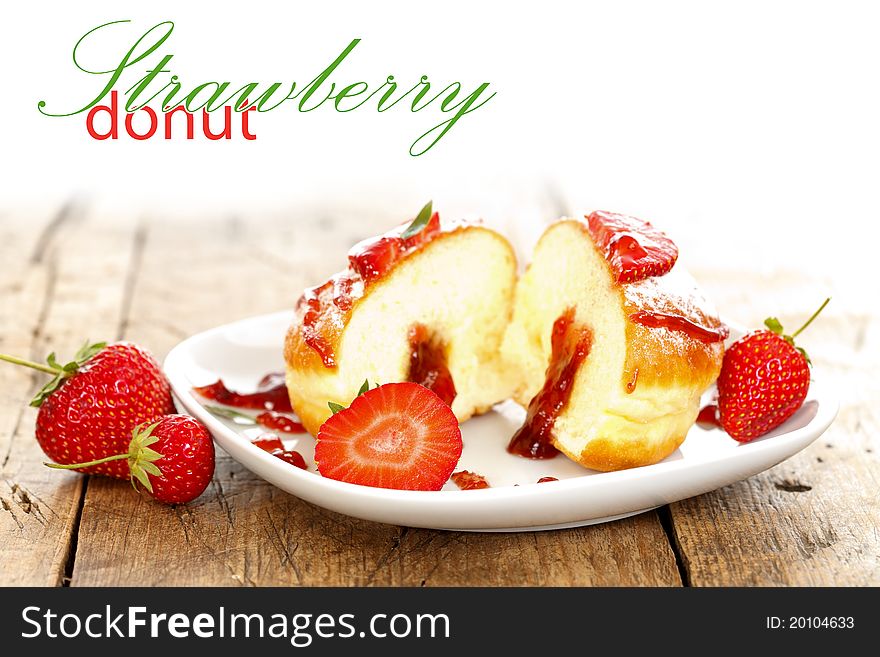 Donut with strawberry jam filling on a plate with place for your text on the left. Donut with strawberry jam filling on a plate with place for your text on the left