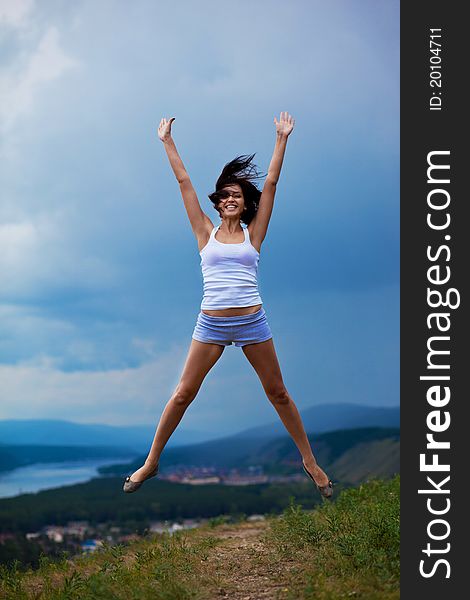 Young woman jumping on a green meadow. Young woman jumping on a green meadow