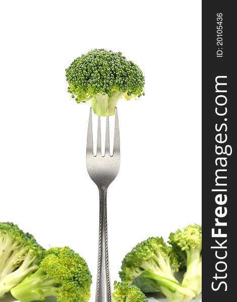 Fresh broccoli on fork with withe background.