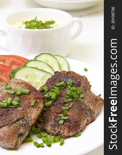 Grilled steak with fresh vegetables in white plate