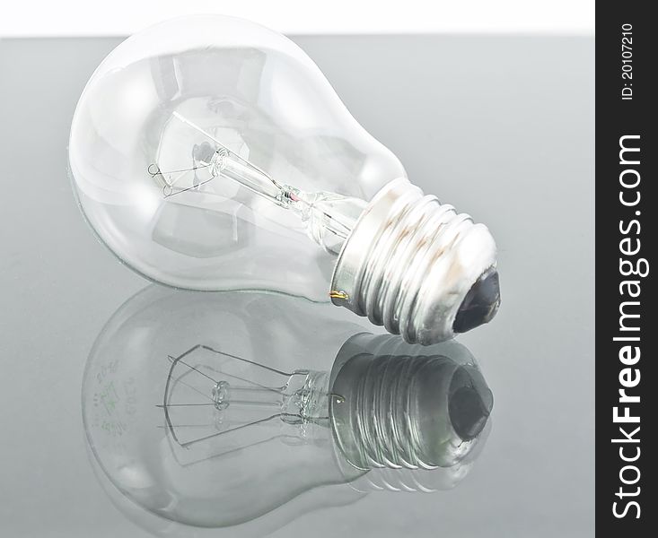 Light bulb isolated on grey background with reflection