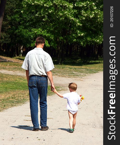 Father and son walking in the park summer day
