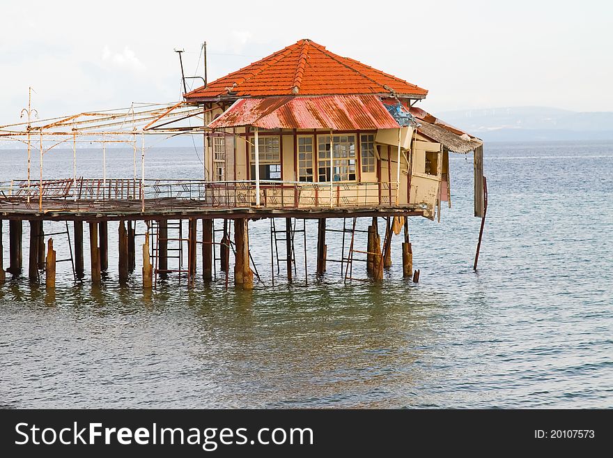 An abandoned pier with a ruined building on its edge, at Edipsos, Greece. An abandoned pier with a ruined building on its edge, at Edipsos, Greece