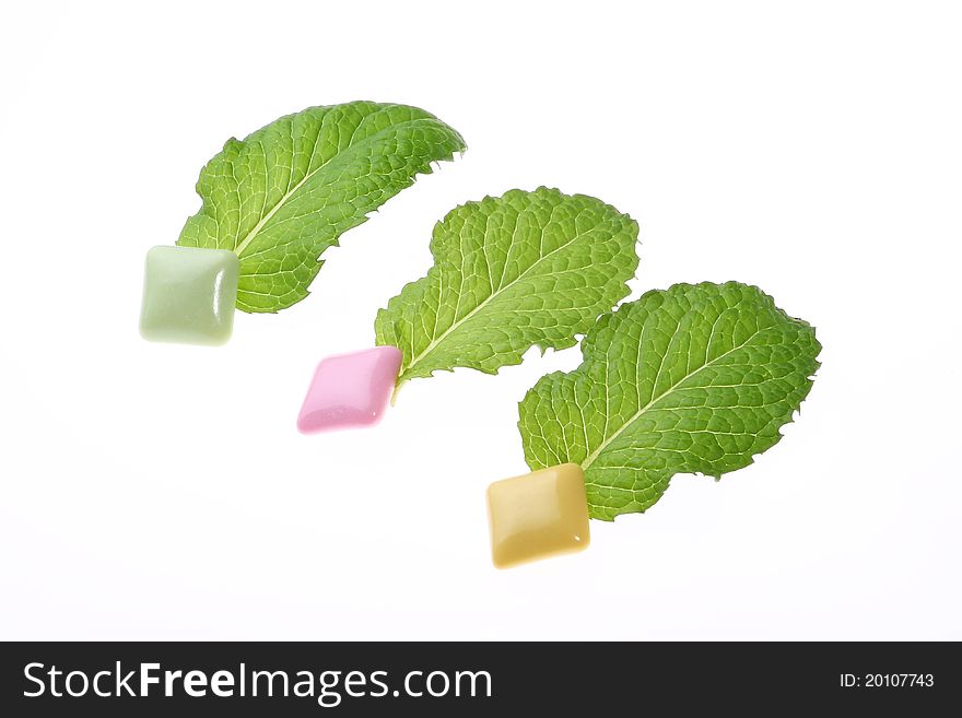 Mint leaf and chewing gum on white background