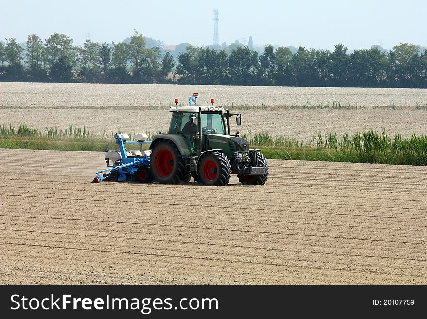 A tractor at work on a dusty field