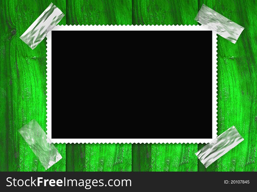 Old picture frame isolated black background, stuck in a wall of green wood. Old picture frame isolated black background, stuck in a wall of green wood