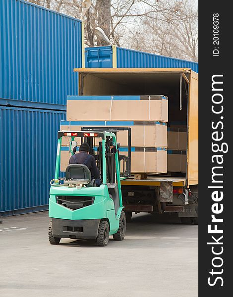 Worker in uniform loading boxes on a machine. Worker in uniform loading boxes on a machine