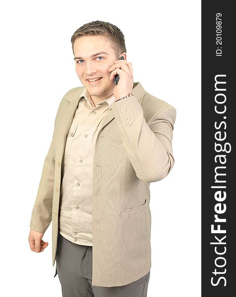 Young smiling businessman calling on phone at office