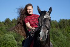Beautiful Girl With Brown Hair On A Black Horse Stock Image