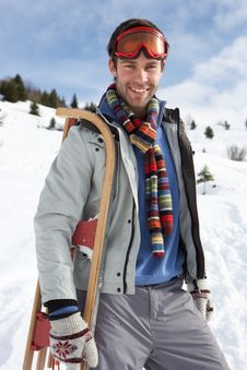 Young Man Carrying Sled In Alpine Landscape Royalty Free Stock Photography