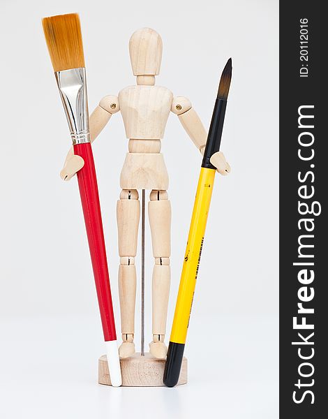 Artist's wooden mannequin with brushes.