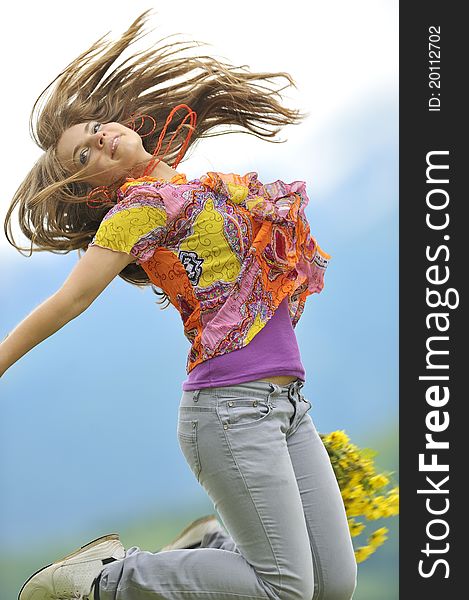 Beautiful woman jump on field in summer time