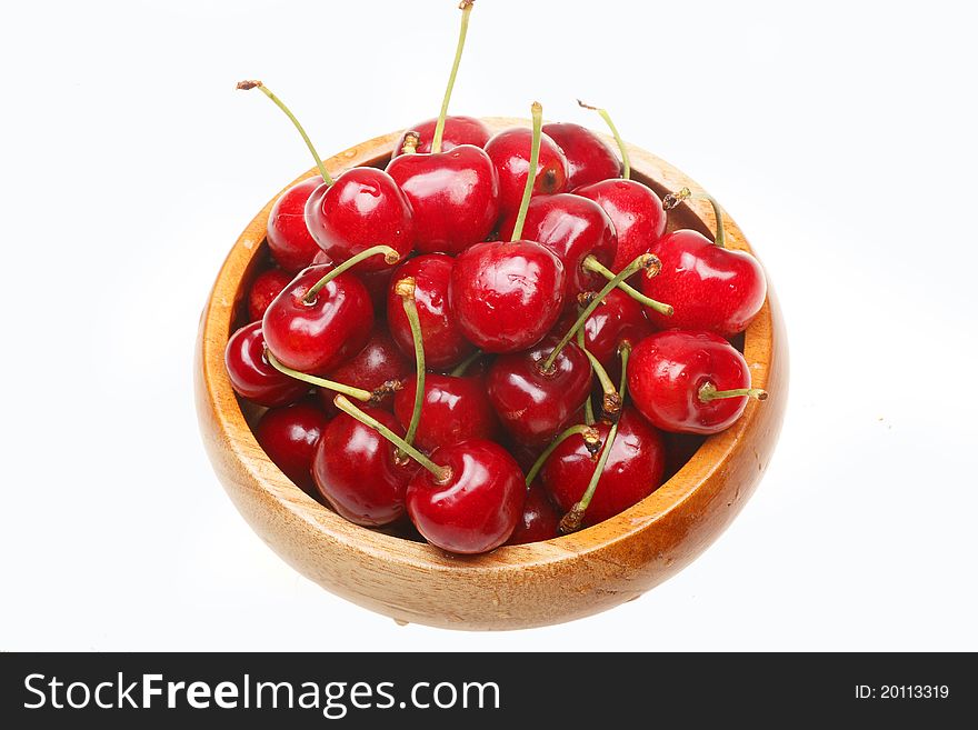 Fresh cherry in the wooden bowl. (Isolated on white)