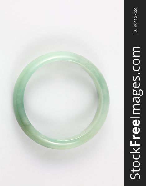 A top view of a green type A jade / jadeite bracelet placed on a white background. The bracelet gives a cloud-like texture inside. Type A means it has not been treated in any way except surface waxing. A top view of a green type A jade / jadeite bracelet placed on a white background. The bracelet gives a cloud-like texture inside. Type A means it has not been treated in any way except surface waxing.