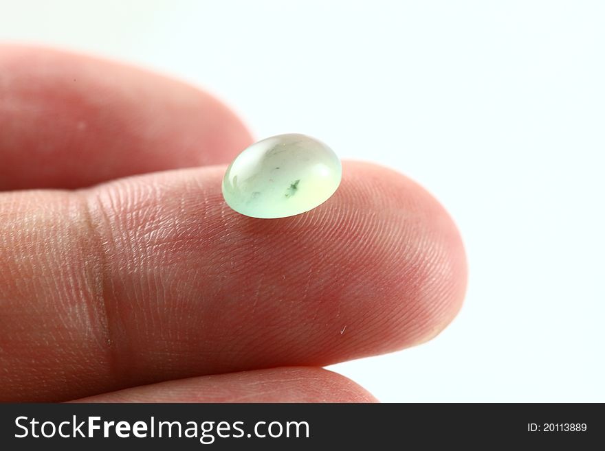A light greenish type A jade / jadeite beads placed on finger top towards a white background. Some green spots could be seen inside. Type A means it has not been treated in any way except surface waxing. A light greenish type A jade / jadeite beads placed on finger top towards a white background. Some green spots could be seen inside. Type A means it has not been treated in any way except surface waxing.