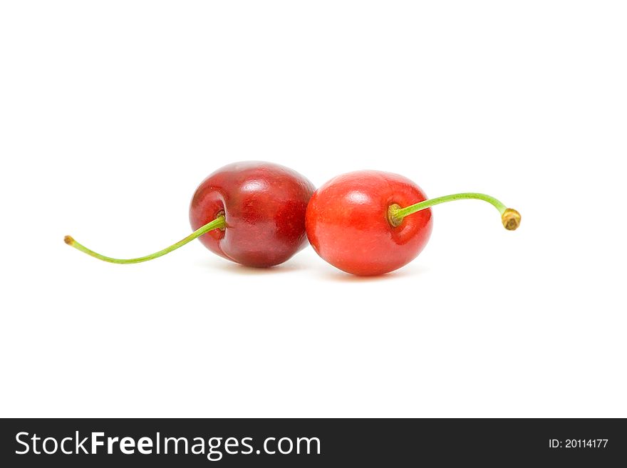 Two ripe cherries on a white background closeup. Two ripe cherries on a white background closeup