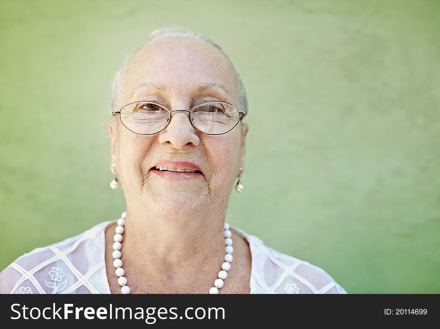 Aged woman with white hair smiling at camera