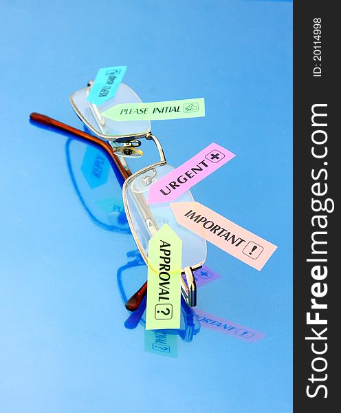 Glasses with priority tags on blue reflective background. Glasses with priority tags on blue reflective background