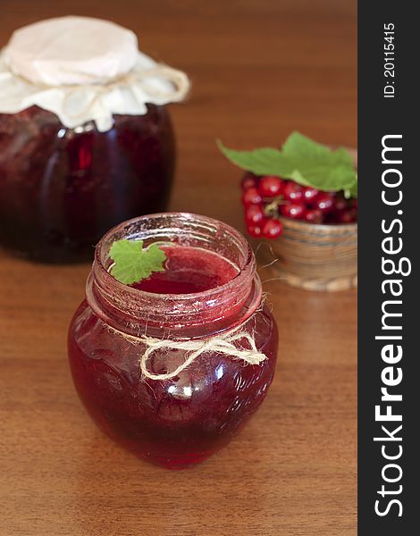 Glass pots of currant jam over wooden table. Glass pots of currant jam over wooden table