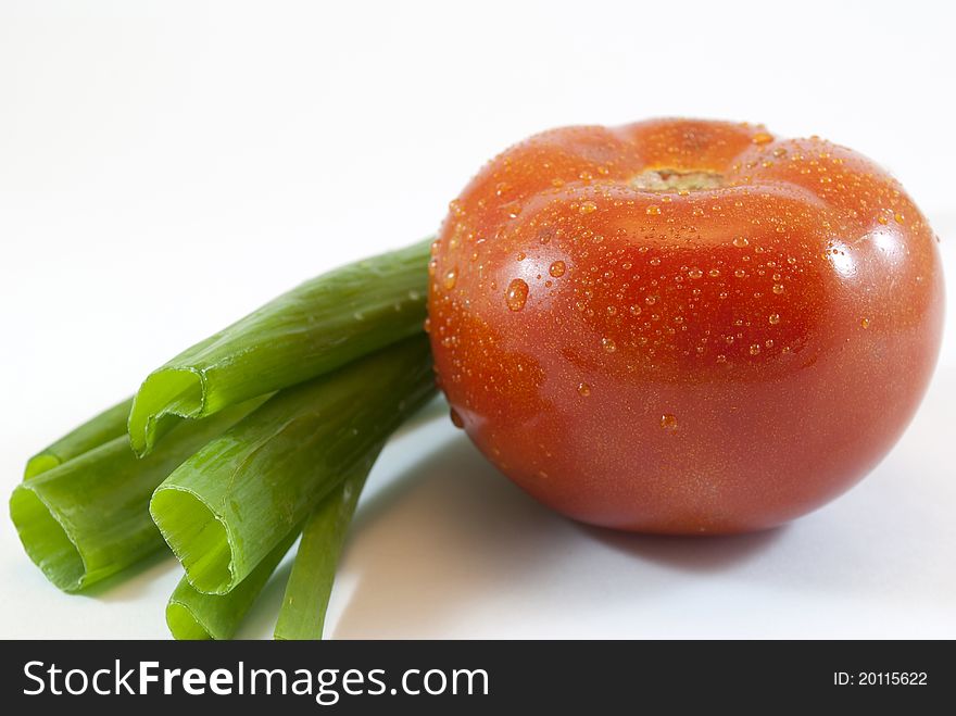 Green onions and tomato isolated on white background