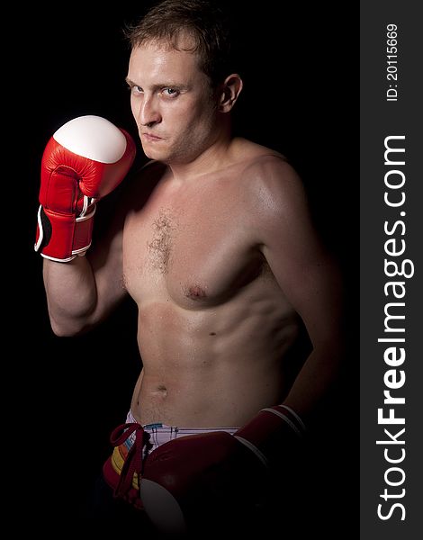 Young Boxer fighter over black background. Young Boxer fighter over black background