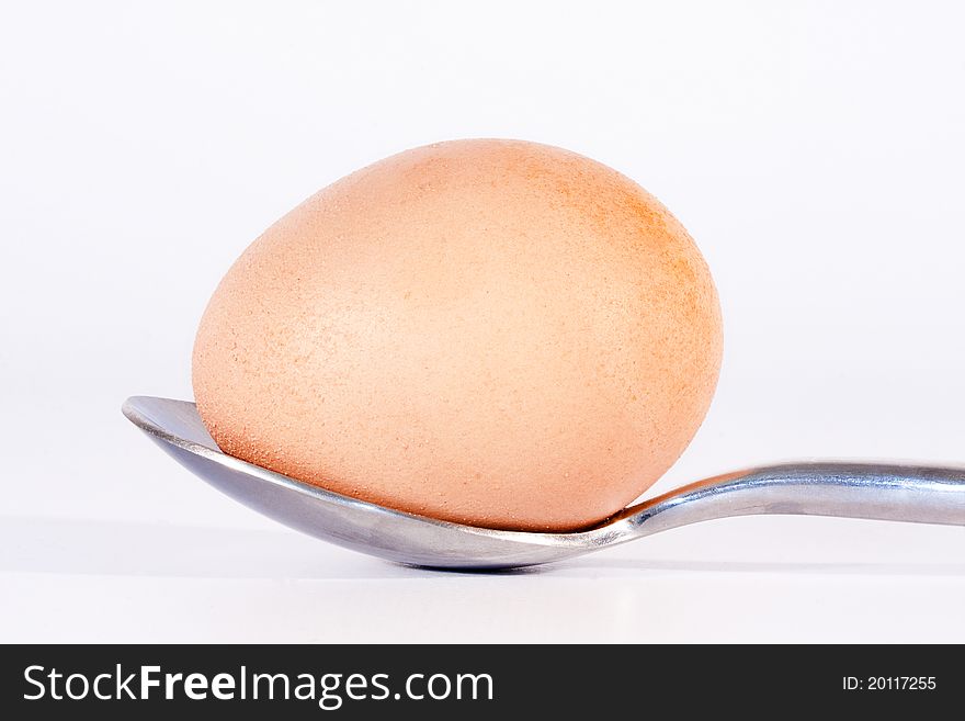 Chicken egg on the spoon on white background. Chicken egg on the spoon on white background