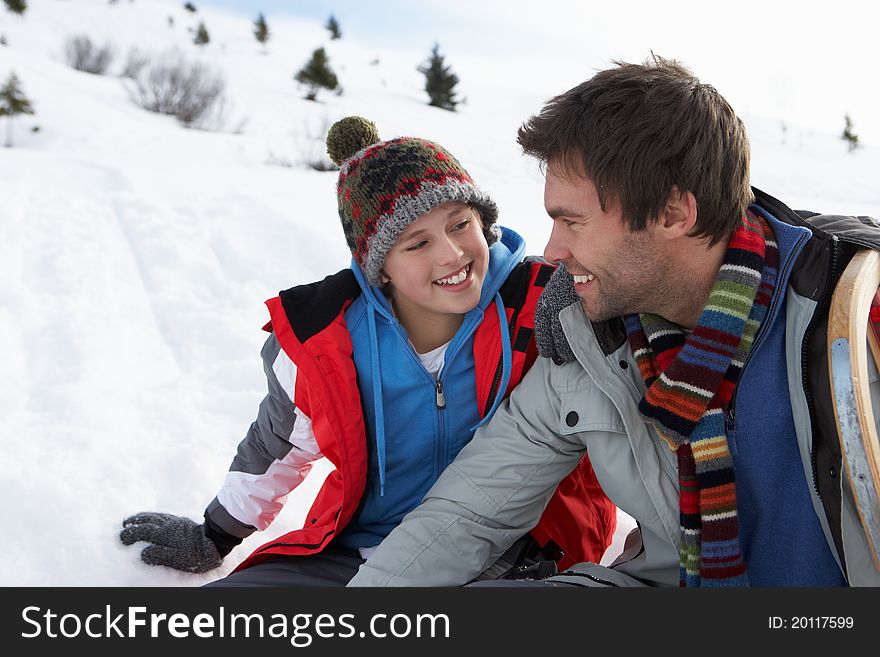 Young Father And Son In Snowy Landscape looking happy