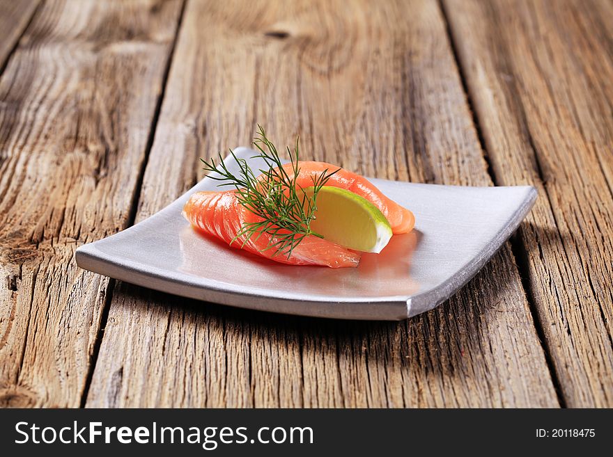 Thin slice of smoked salmon and wedge of lime. Thin slice of smoked salmon and wedge of lime